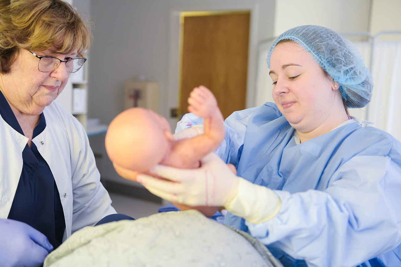 Current graduate student Ashley Porter simulates a birth with new technology.
