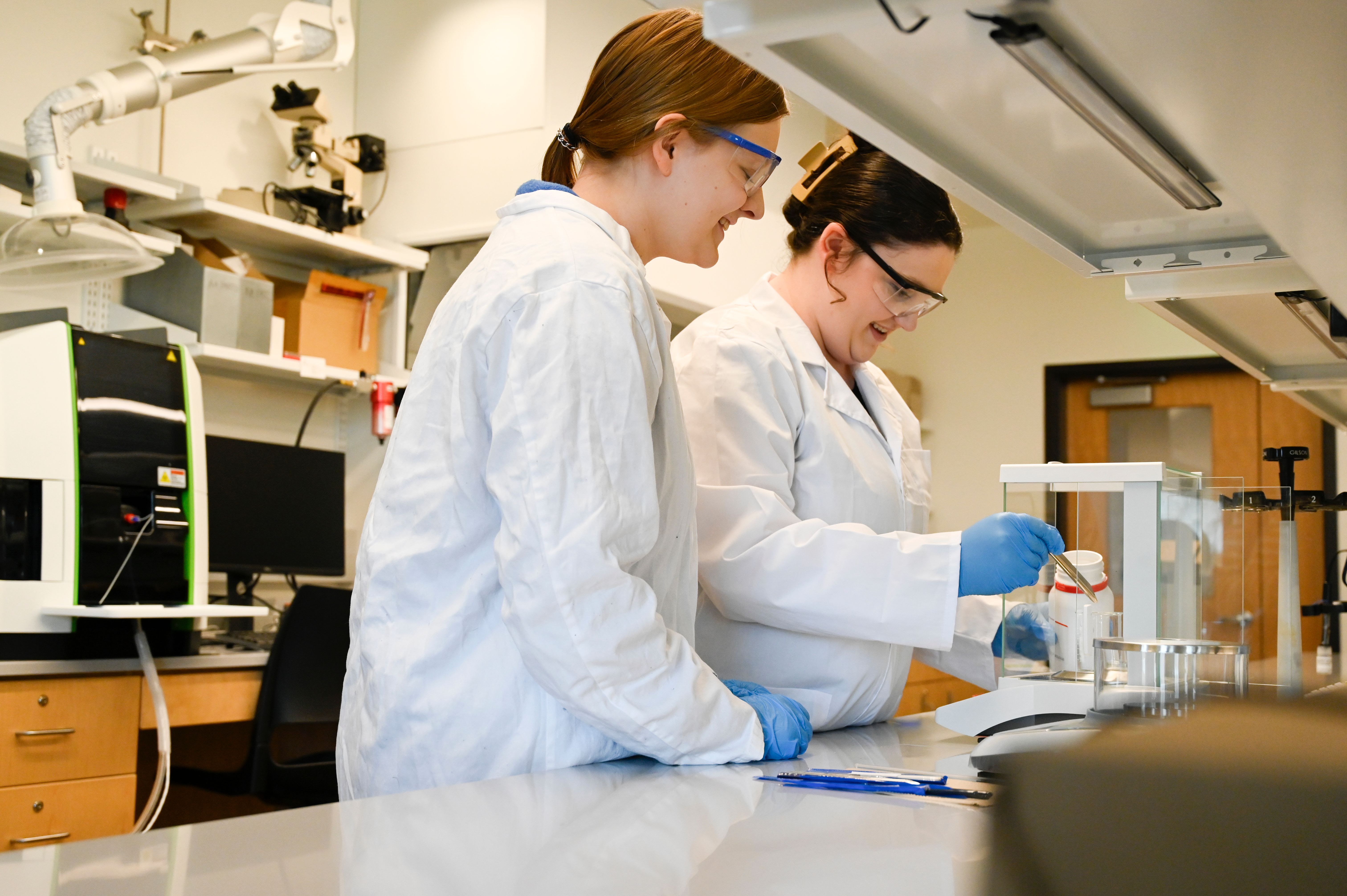 Chemistry majors Bailey Dassow, left, and Brinkley Bolton, right, do pesticide research in the lab.