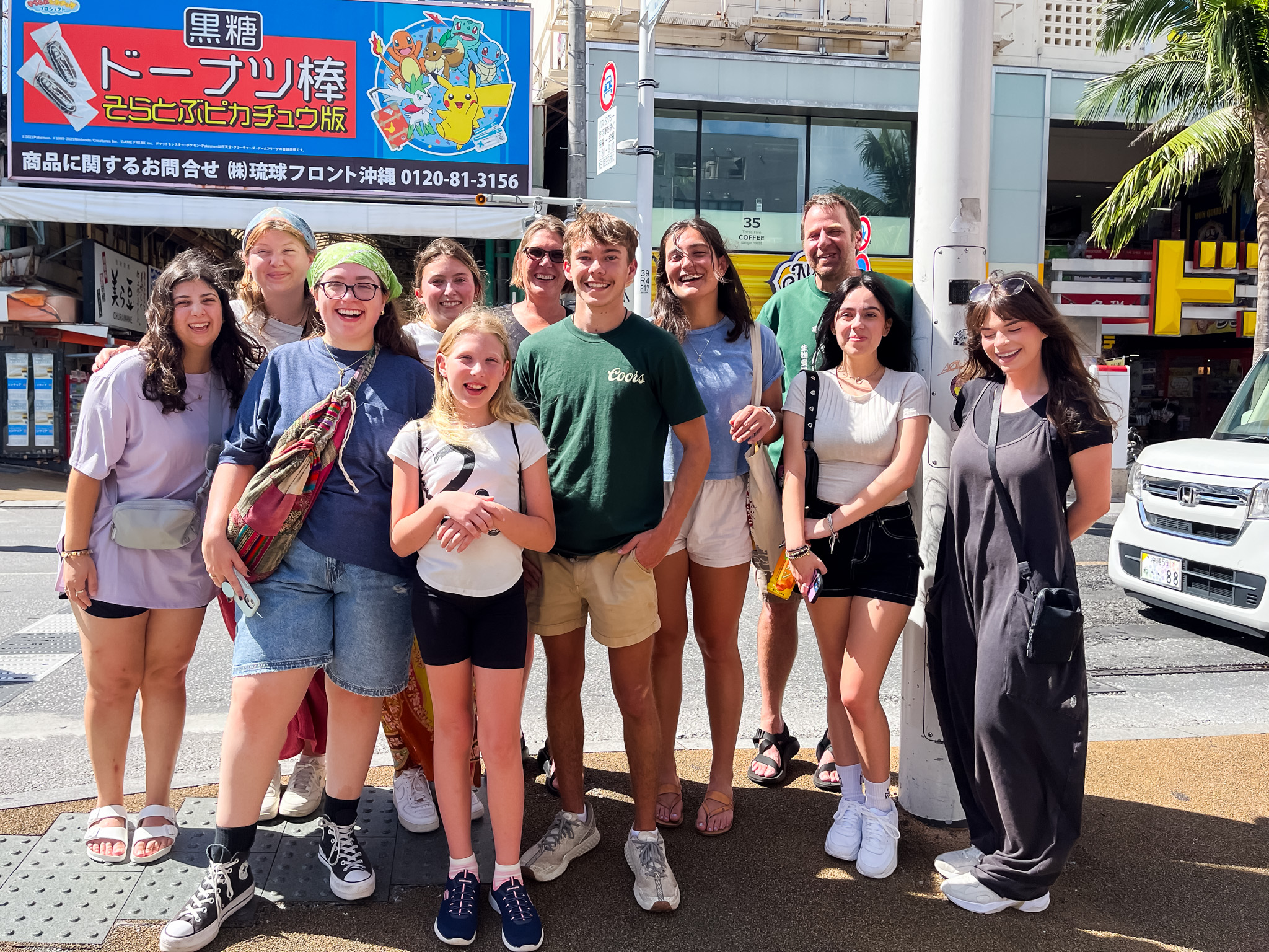 A group photo in front of a busy street in Japan.