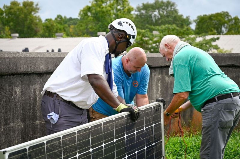 Participants in GCSU's first solar business course inspect a solar panel before installation recently at the water district in Baldwin County.