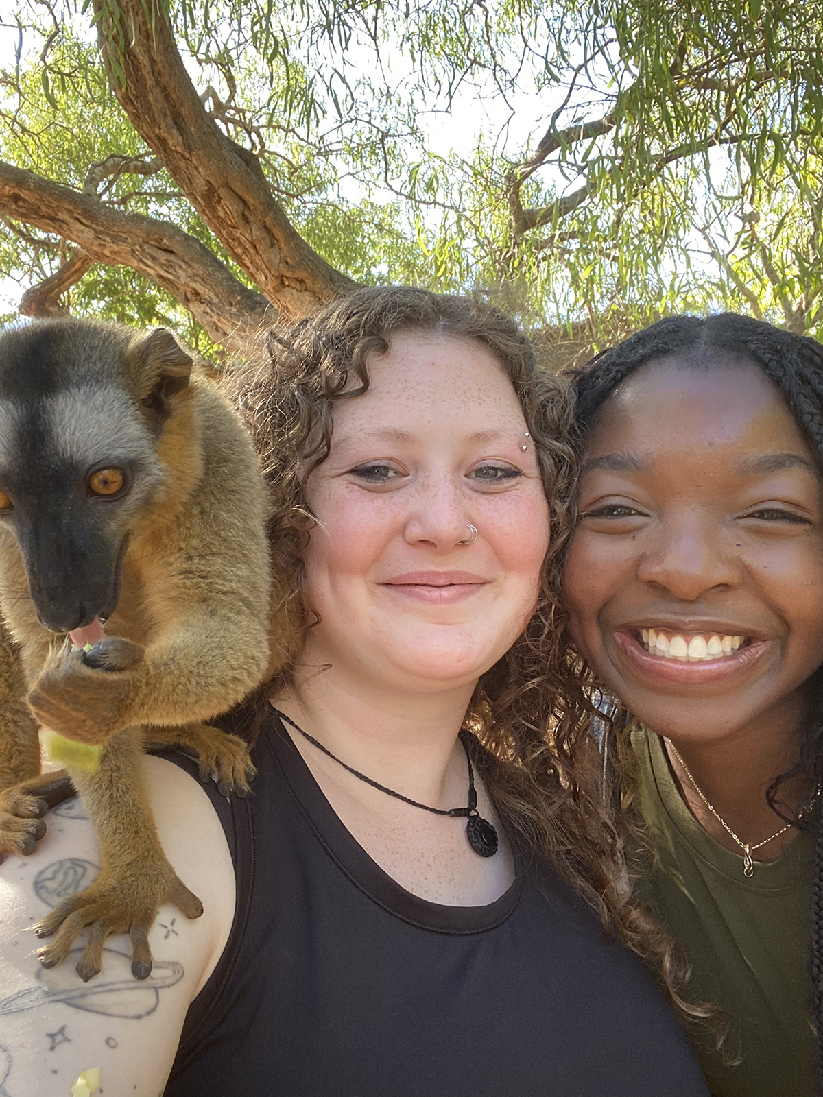 Kara Drake-center-sports a lemur on her shoulder.