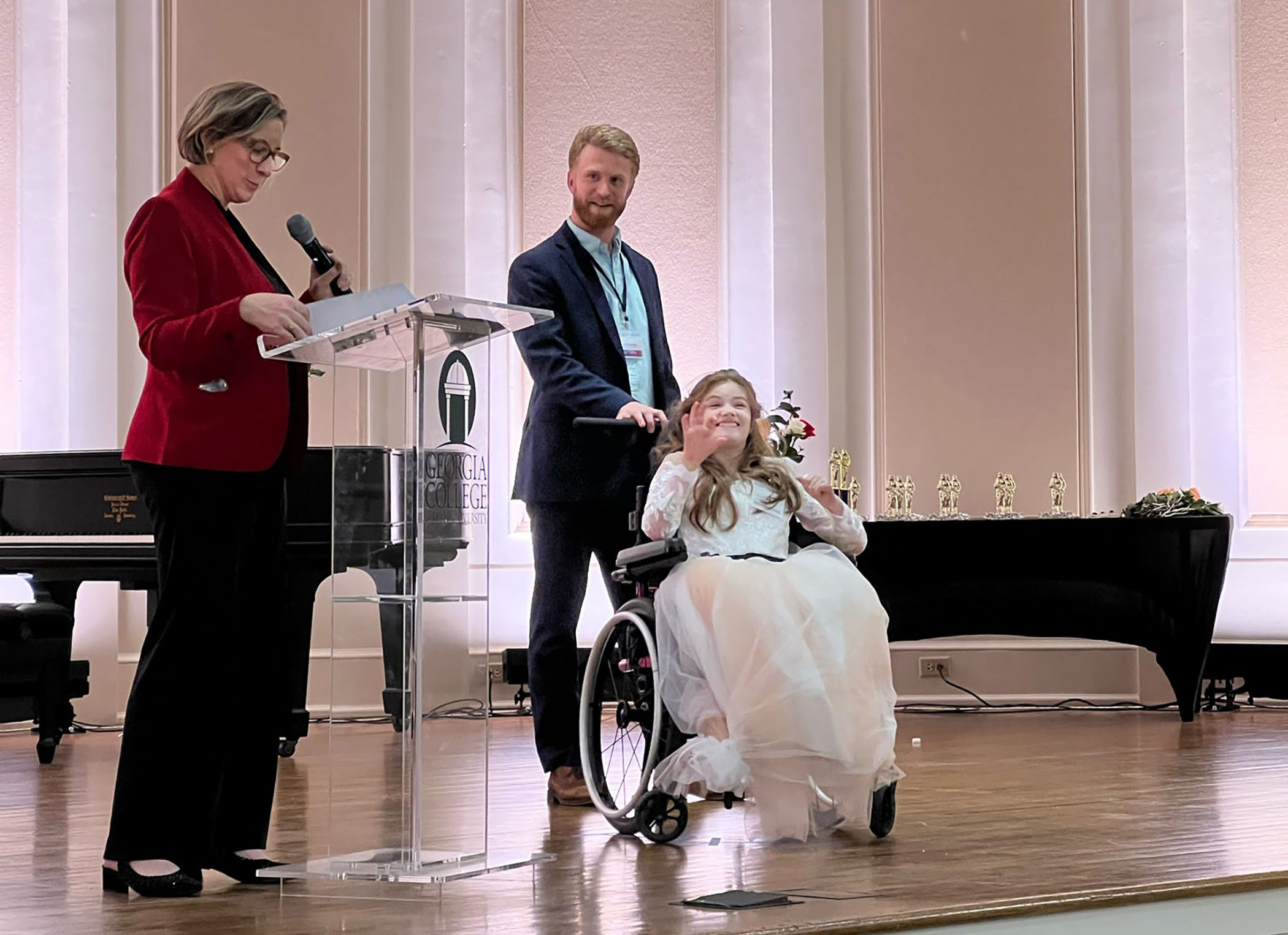 Ethan Bearden with a Miss Amazing contestant on stage