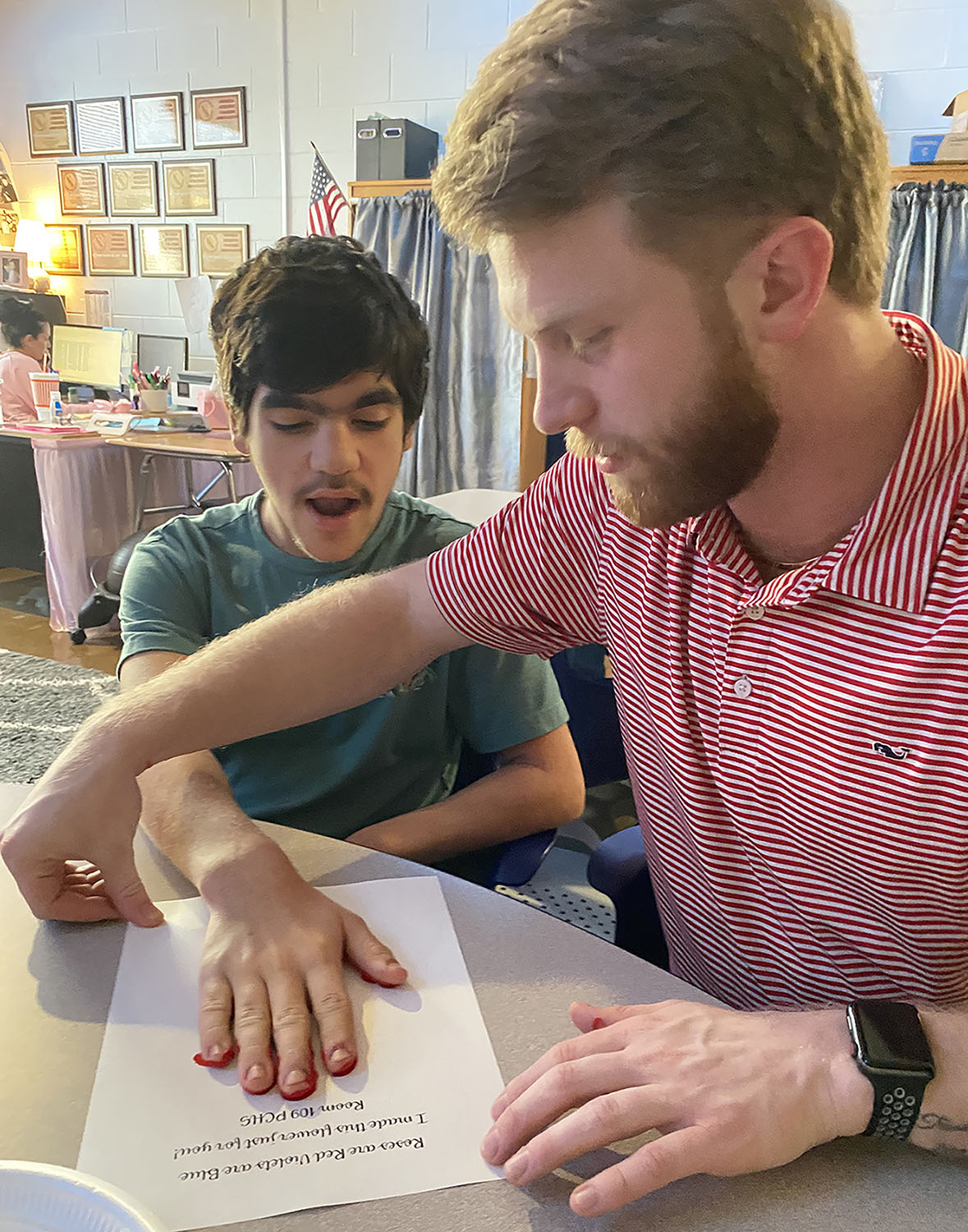 Ethan Bearden ('25) helps a student make handprint art. (Photo: Ethan Bearden)