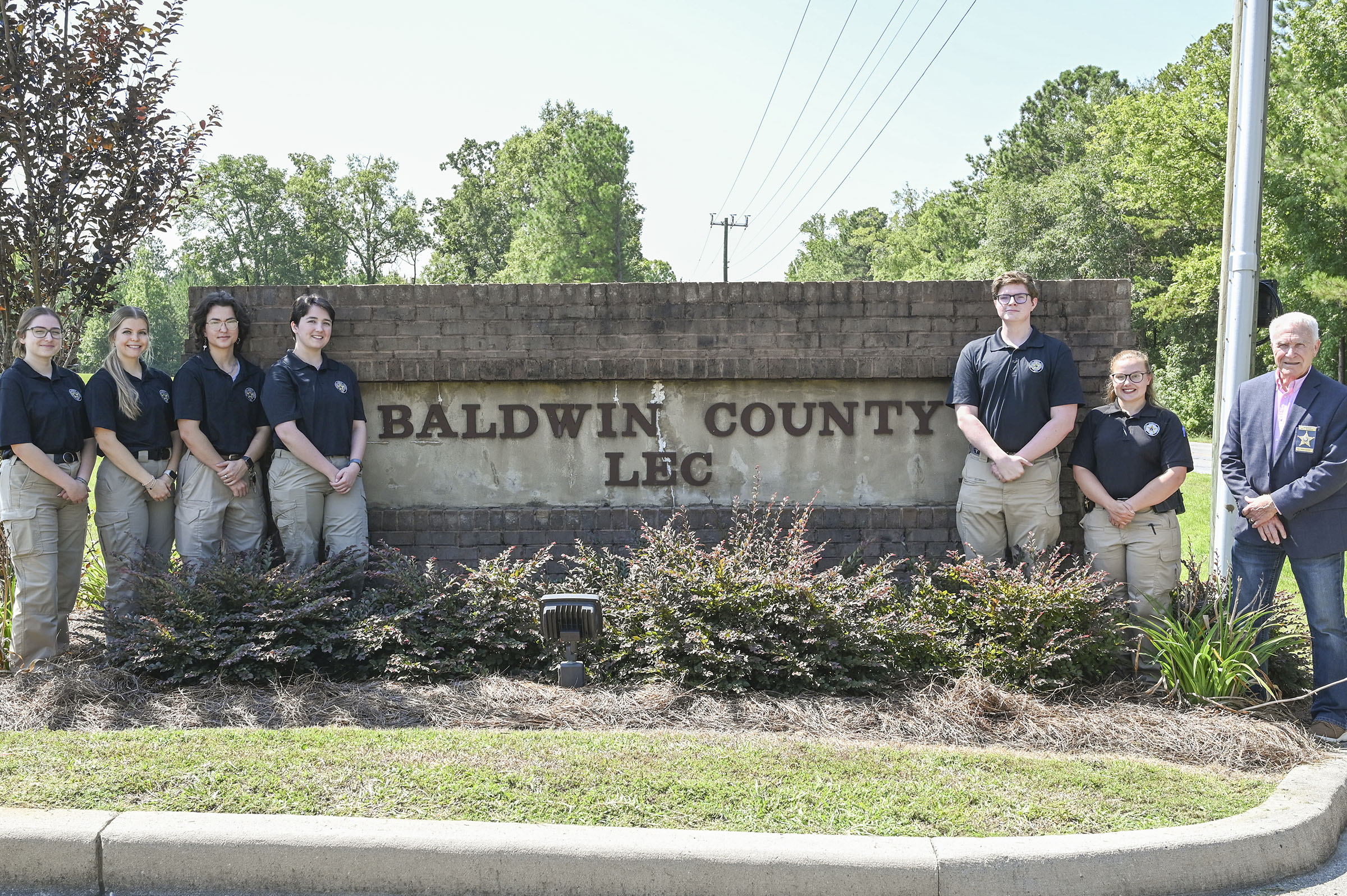 From left: Bobcat senior Olivia Crawford, alumna Maddie Brown (’25), alum Skye Mears (’25), senior Wesley Whitehead, junior Ezra Ryall, Real Time Crime Center Director Evelyn Johnson (’24) and Baldwin County Sheriff Bill Massee (’70).