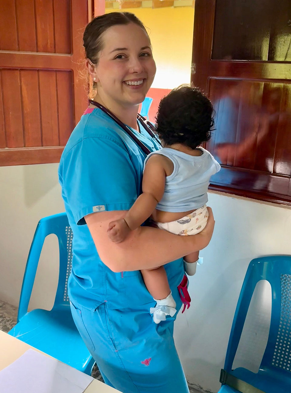 Nursing graduate student Grace McGibbon holds a young patient. (Photo: Grace McGibbon)