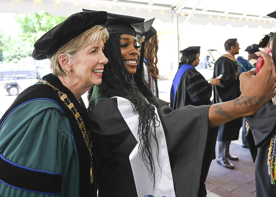 President Cathy Cox poses for a post-commencement selfie with a graduate. (Photo: Anna Gay Leavitt)