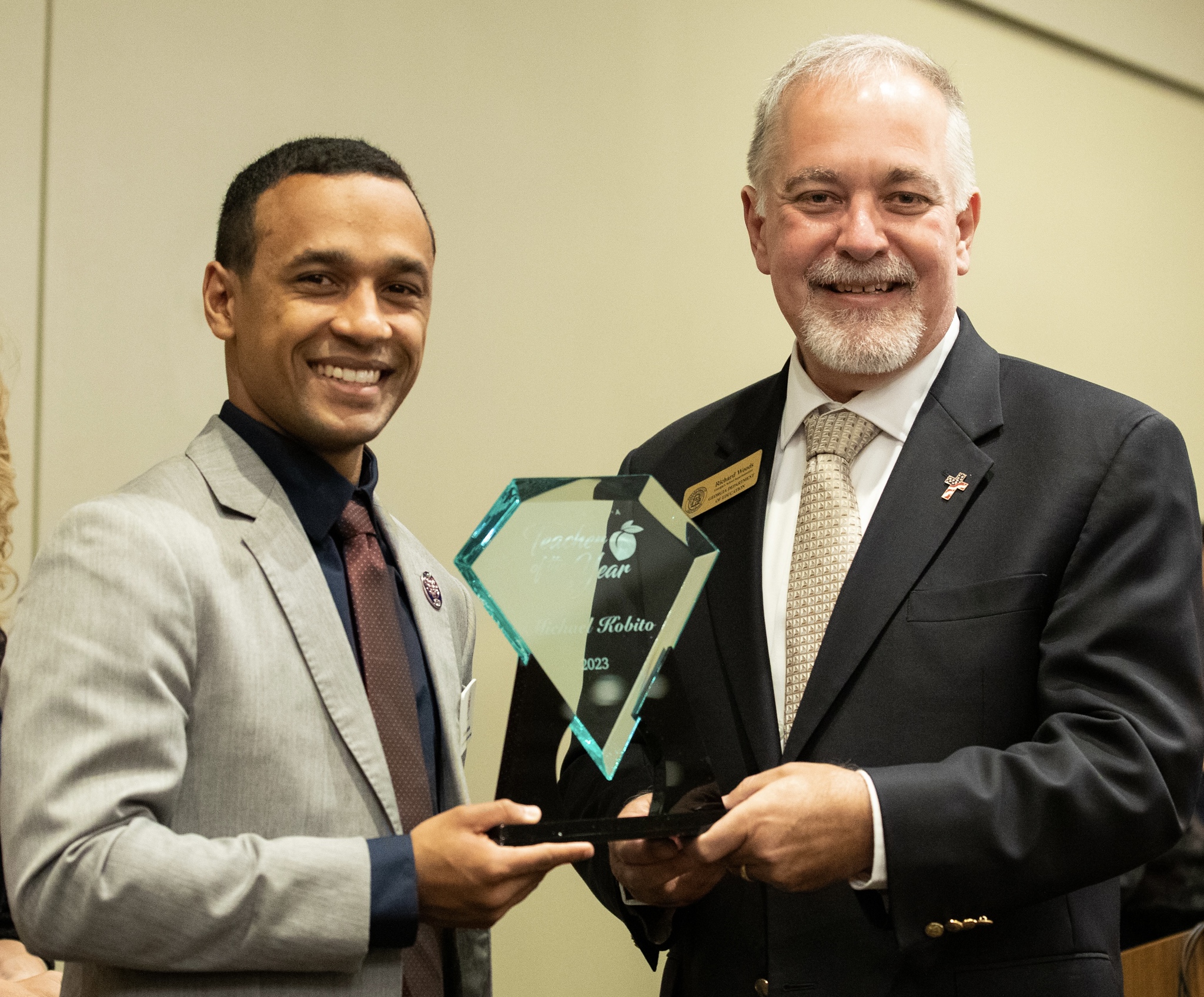 Kobito and his Georgia 2023 Teacher of the Year award with Richard Woods, superintendent for the state of Georgia.