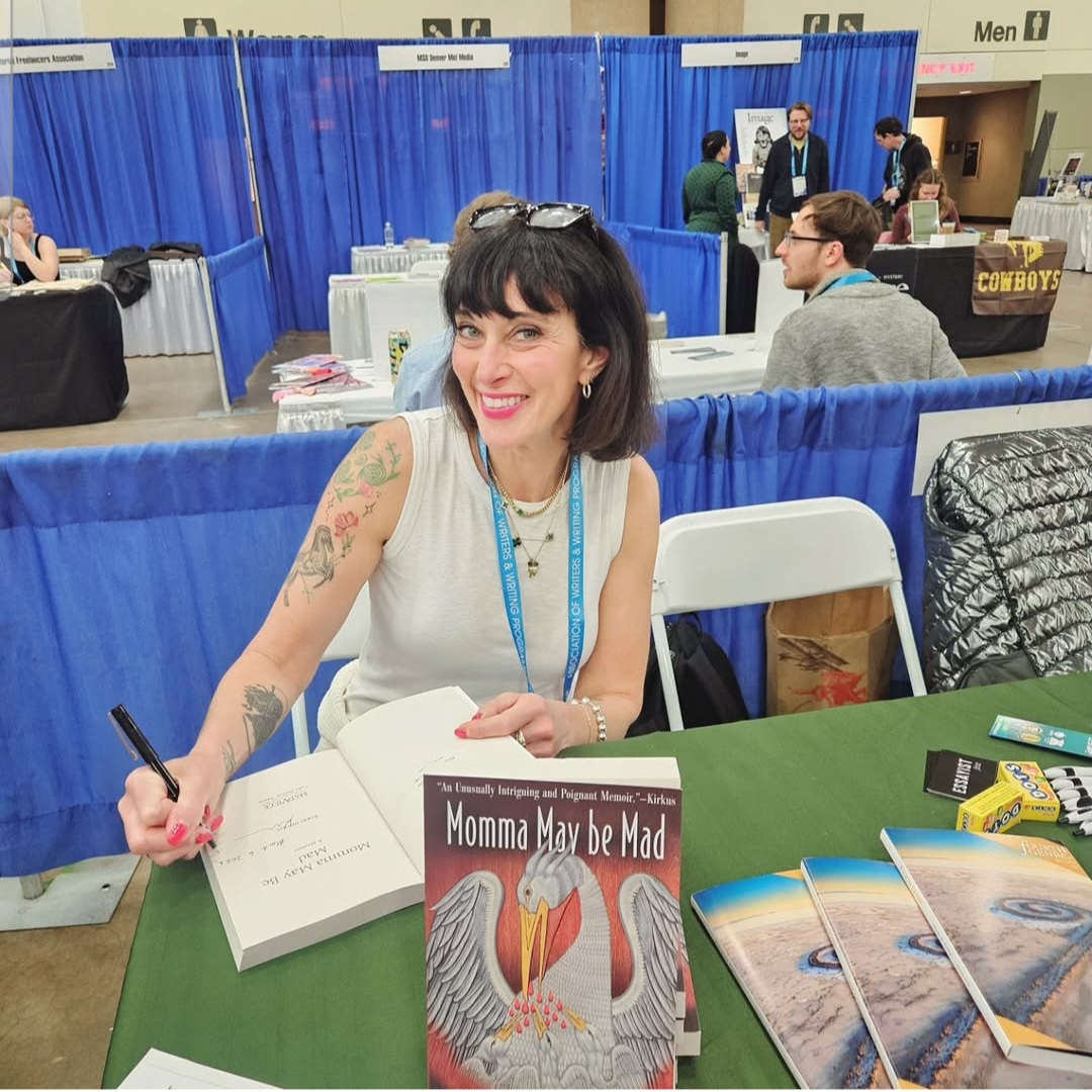 Neville signing ‘Momma May Be Mad’ at the Associated Writer’s Conference