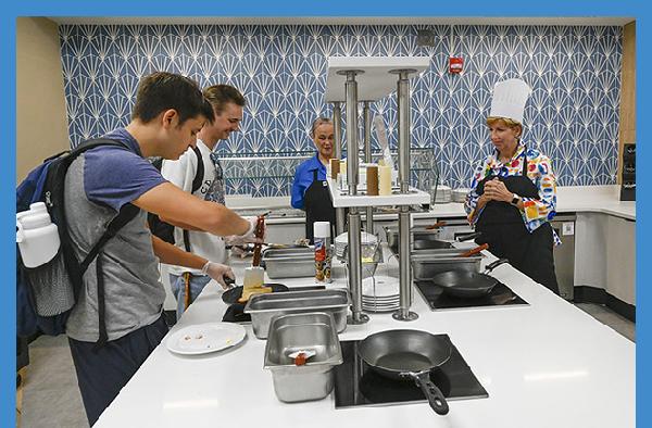 GCSU President Cathy Cox observes students preparing their meals at the new U-Cook station at The Max