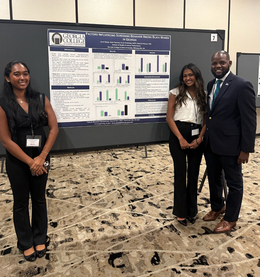 Students Janvi Desai and Asia Pearson stand with their winning poster presentation at the 2025 Cancer Research Symposium. They a