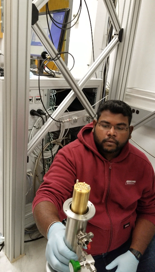 Dr. Kushan Wijewardena gets ready to load a sample into the dilution refrigerator.